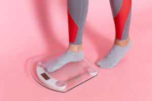 A woman weighing herself on a digital weighing scale